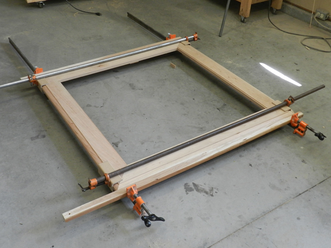 photo of mitered and doweled boards used to build the coffee table top glued and clamped together