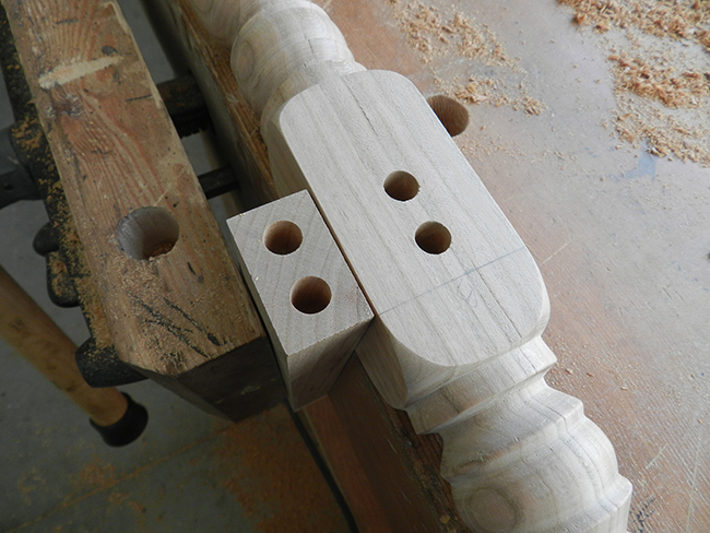 photo of drilled bores of dowel joint used to build the counter stool frame lower rail to leg assembly