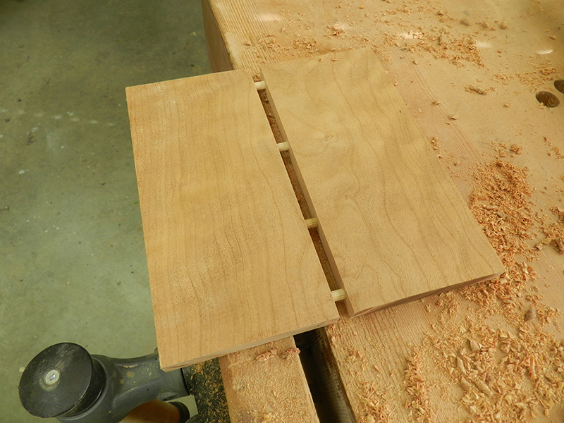 The plant stand lower shelf work piece cut into two and rejoined with 1/4 inch dowels to remove cup and bow.