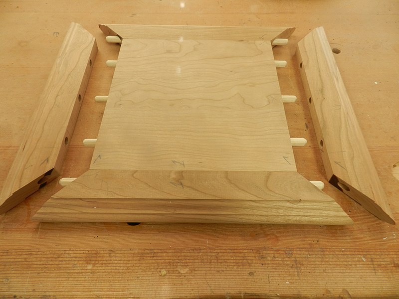 The plant stand top plate and mitered rails partially fitted to show the orientation of the dowel connections.
