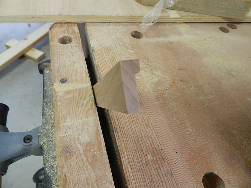 Shape of decorative moulding for plant stand top perimeter rails after being cut in table saw.