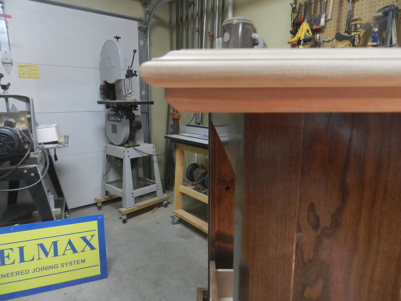 photo of mitered perimeter rail added to underside of the armoire top plate to provide a thicker appearance