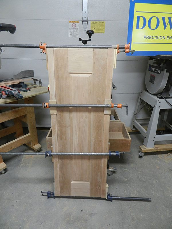 photo of raised panel assembly and both corner posts used to build the armoire frame assembly side section shown glued and clamped together