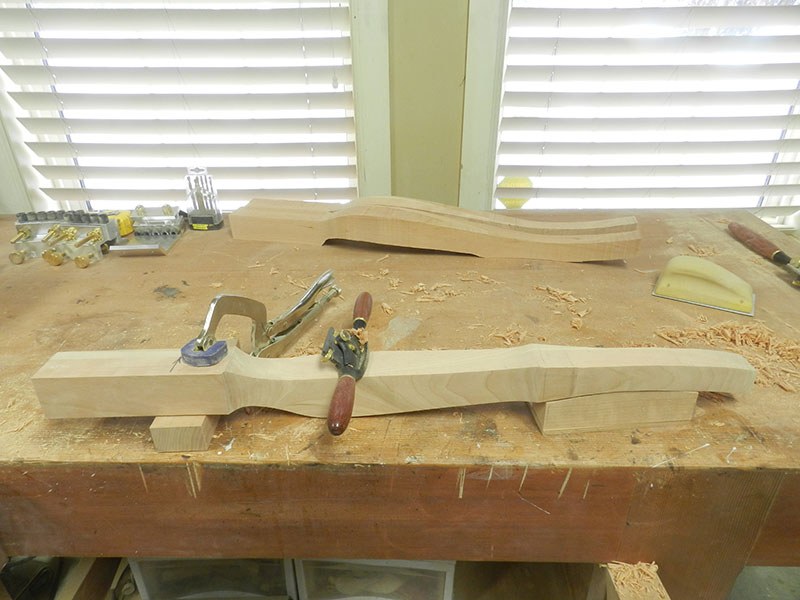 photo of the bench top clamping arrangement for shaping the cabriole leg used to to build the bedside table frame with cut outs from the band saw sectioning process