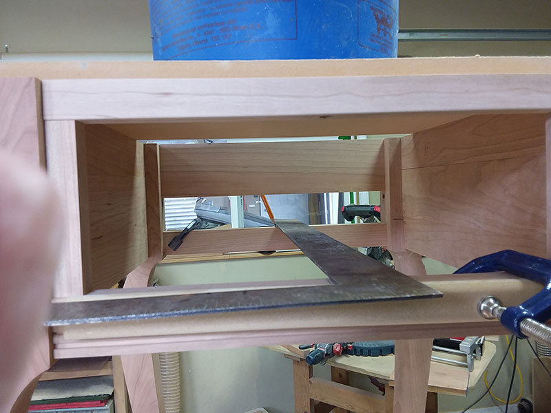 photo of method of determining the center line on the front and rear lower drawer rails using a long machinists square